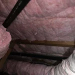 A room with pink insulation and a metal frame.